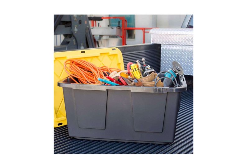 Caja organizadora negro/amarillo de 27 galones GreenMade, abierta y llena de herramientas eléctricas y cables en una