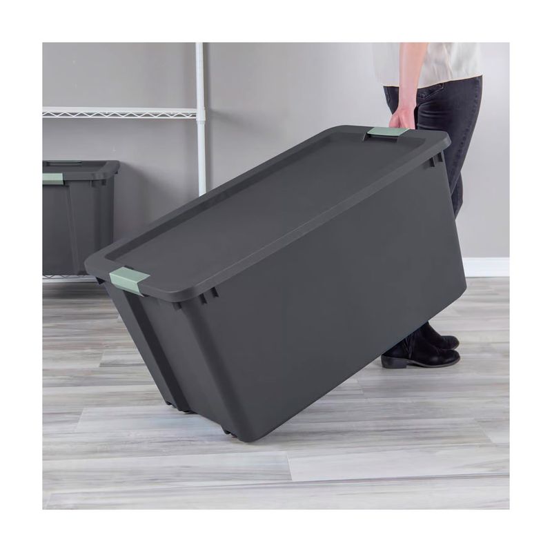 Caja organizadora 45 galones con tapa gris oscuro Sterilite, siendo trasladada por una persona en un ambiente interior
