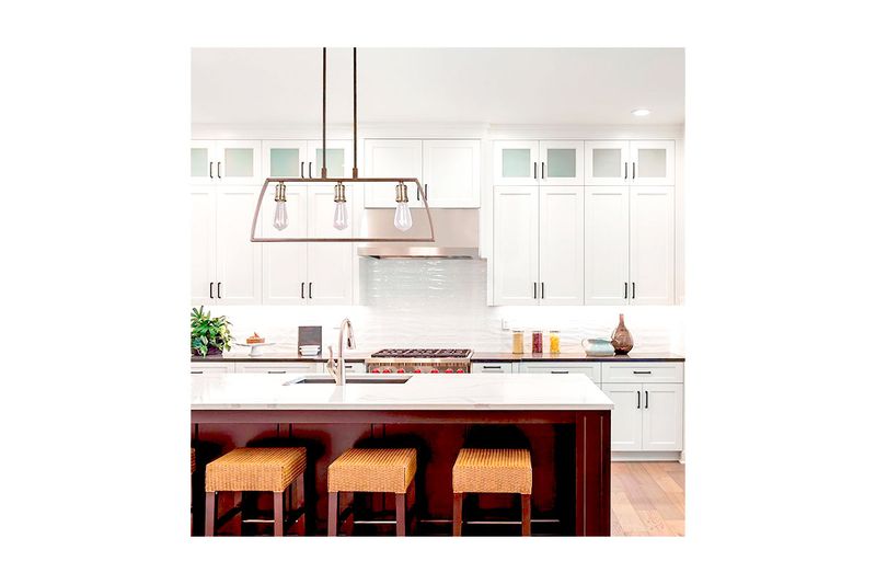 Lámpara de techo chocolate 3L E27 60W Sinsa, instalada sobre una isla de cocina blanca con taburetes de mimbre