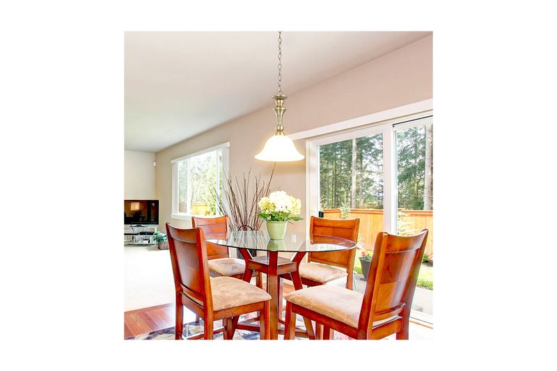 Lámpara colgante bronce antiguo 1L E27 60W Sinsa, instalada sobre una mesa de comedor de vidrio con sillas de madera