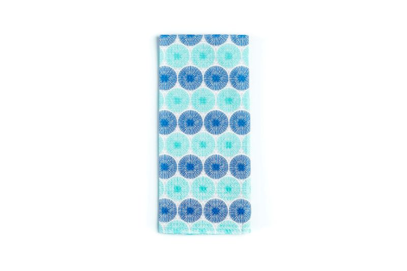 Toalla para cocina Starburst morado Sttelli, vista cenital del tejido doblado con estampado de círculos radiales azules