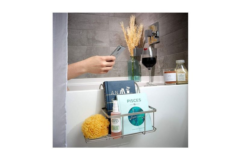 Bandeja organizadora de baño colgante pequeña plata mate iDesign, instalada en tina con libros y accesorios de aseo