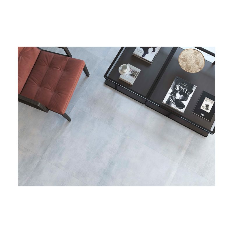 Porcelanato 90x90 Zen Grey mate rectificado Metropol, instalado en piso con muebles de sala y libros encima