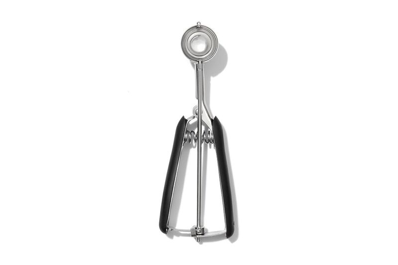 Cuchara para helados y galletas negro acero inox OXO, vista frontal cenital del utensilio extendido sobre fondo blanco