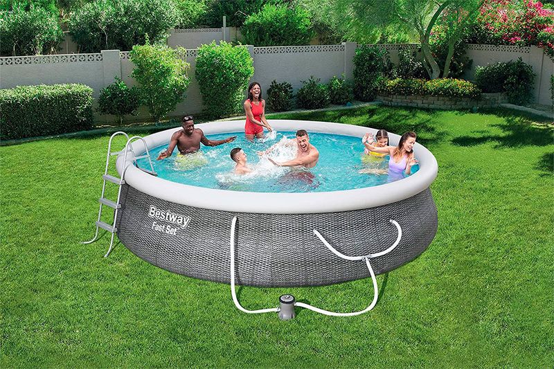 Set piscina redonda Fast Set gris de 4.57 m de diámetro por 1.07 m de alto Bestway, instalada en jardín con personas y