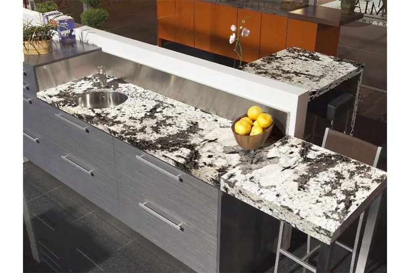 Granito brasileño 2 cm white nevado Pedra Do Frade, instalado como encimera de cocina con fregadero y barra