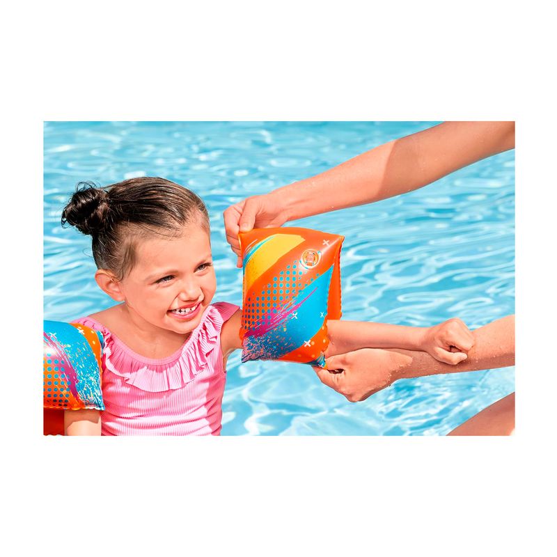 Mangas flotantes para niños 3 a 6 años multicolor Bestway, niña usándolas en una piscina mientras un adulto la ayuda