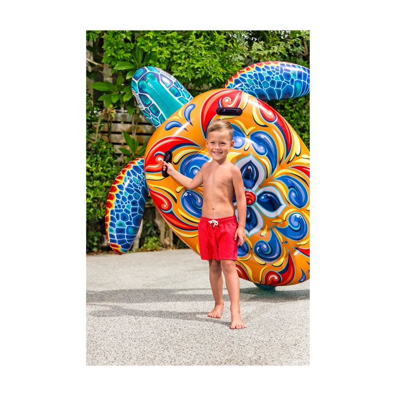 Flotador inflable para niños diseño tortuga multicolor Bestway, niño pequeño sonriendo abrazado al flotador en un jardín