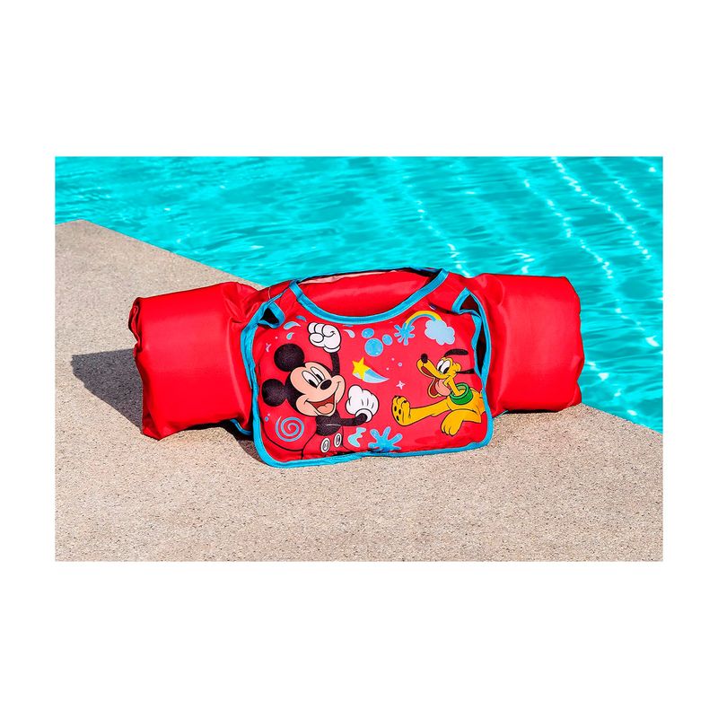Chaleco flotador infantil con mangas 3 a 6 años Mickey rojo Bestway, extendido sobre el piso junto a una piscina