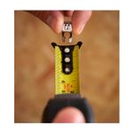 Cinta métrica Control Lock Stanley de 1 pulgada x 8 mts, detalle del gancho metálico siendo colocado en la cinta amarilla