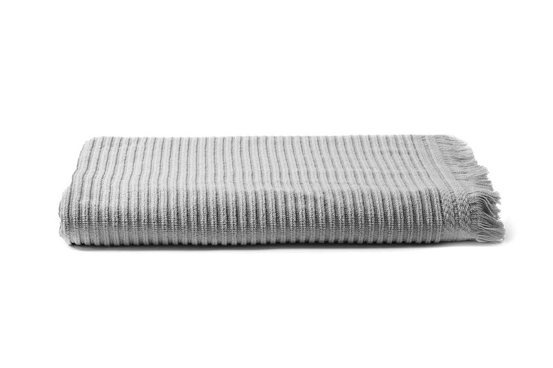 Toalla para baño 53x27 pulgadas Euphoria gris Sttelli, doblada mostrando la textura de rayas y el borde con flecos