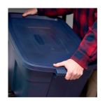 Caja organizadora con tapa 31 galones plástico navy Rubbermaid, primer plano de manos cerrando la tapa azul