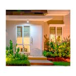 Puerta metálica Amparo 70 cm x 210 cm Puertas Globales, instalada en la entrada de una casa con paredes blancas y jardín