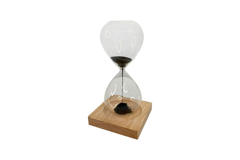 Juego de reloj de arena decorativo 9 x 20 cm Concepts, vista lateral con arena negra sobre base de madera clara