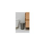 Papelera para baño gris moldeado Plast Umbra, ubicada en el suelo junto a un inodoro blanco y un mueble de madera