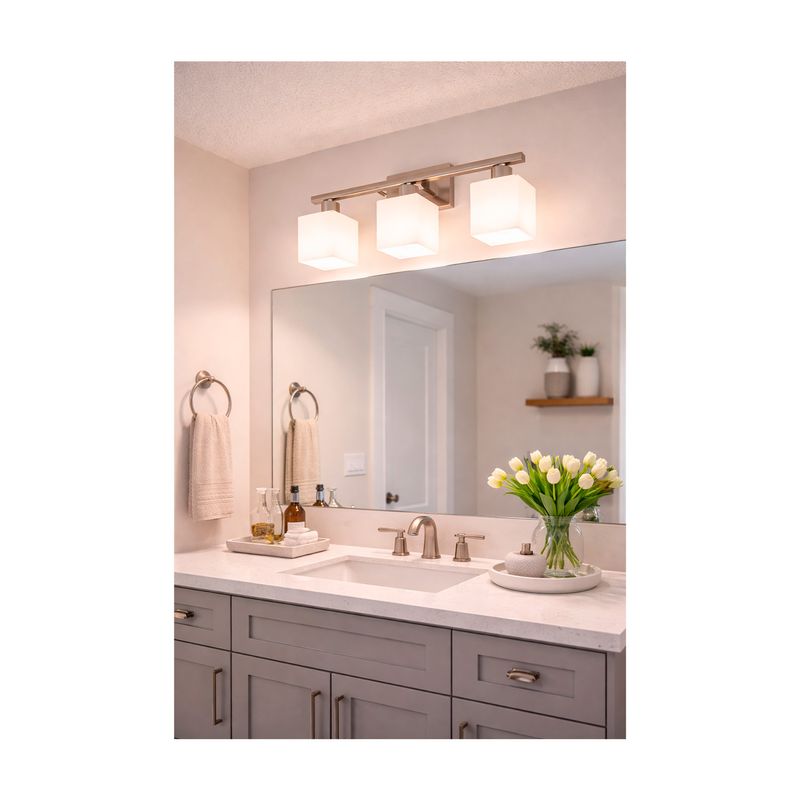 Lámpara pared Fariza níquel satinado 3 luz E27 60W Ikelite, instalada sobre un espejo de baño con luz encendida