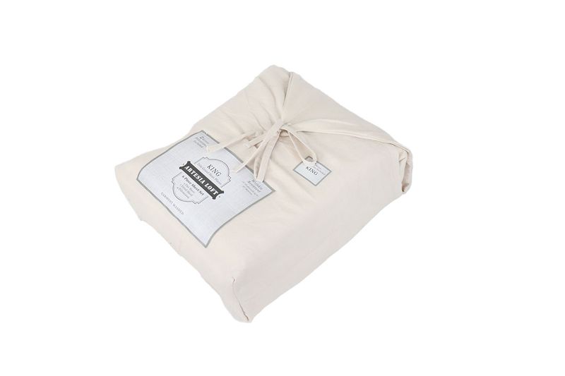 Juego de sábanas King 6 piezas crema Solid Washed CHD Home, doblado en su empaque de tela con etiqueta y lazo