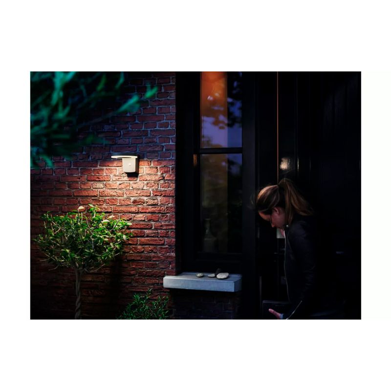 Luminaria solar de pared Zonal RD 4V 1.3W 250lm 3000K IP44 con sensor negro Philips, instalada en pared de ladrillo encendida