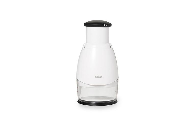 Picador de alimentos pequeño crema Oxo, vista frontal del cuerpo blanco con recipiente transparente y tapa negra