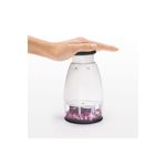 Picador de alimentos pequeño crema Oxo, mano presionando el botón superior con cebollas picadas en el recipiente