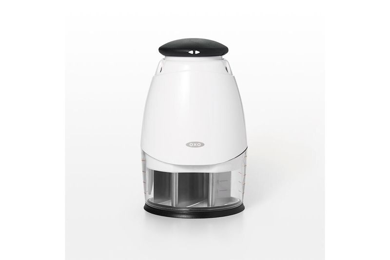 Picador de alimentos pequeño crema OXO, vista frontal del equipo con tapa negra y recipiente transparente