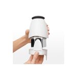 Picador de alimentos pequeño crema OXO, manos separando el recipiente para mostrar las cuchillas internas de metal