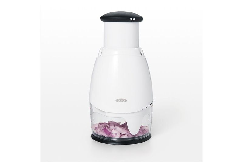 Picador de alimentos pequeño crema Oxo, vista frontal del equipo con cebollas picadas en su interior
