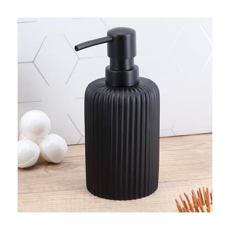 Dispensador de jabón estriado poliresina 230 ml negro Tendance SINSA, vista frontal sobre superficie de madera con esferas