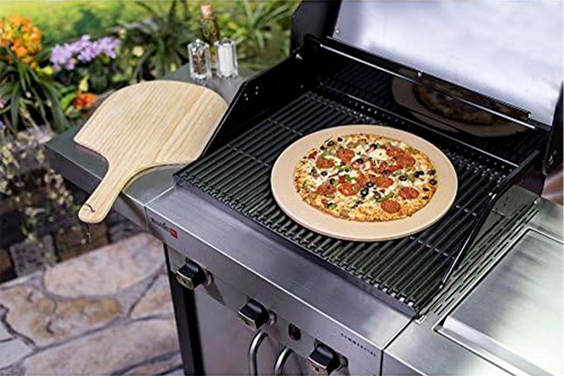 Kit piedra para pizza 15 pulgadas y paleta madera Char-Broil, piedra con pizza cocida sobre parrilla y paleta al lado