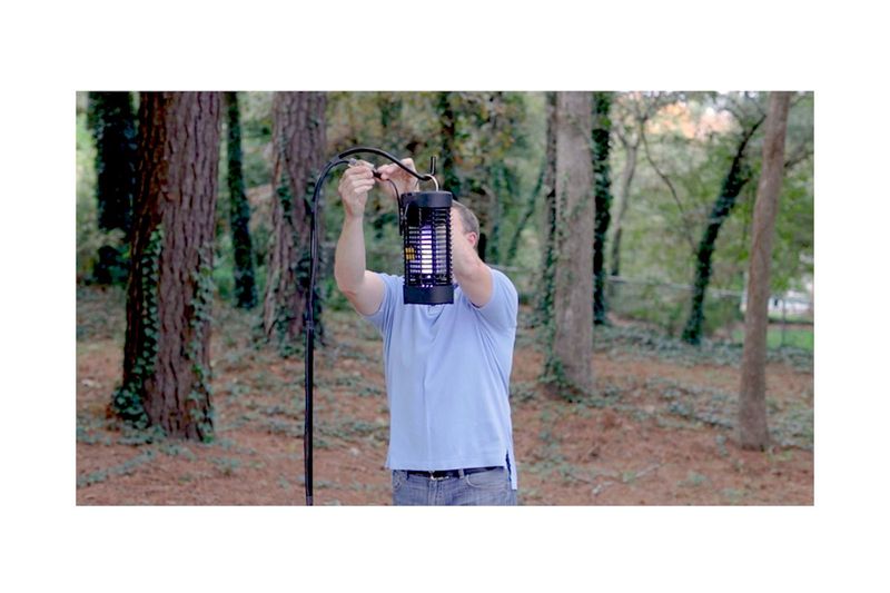 Exterminador de insectos eléctrico 1/2 acre 20 W Black Flag, hombre sosteniendo el dispositivo en un bosque