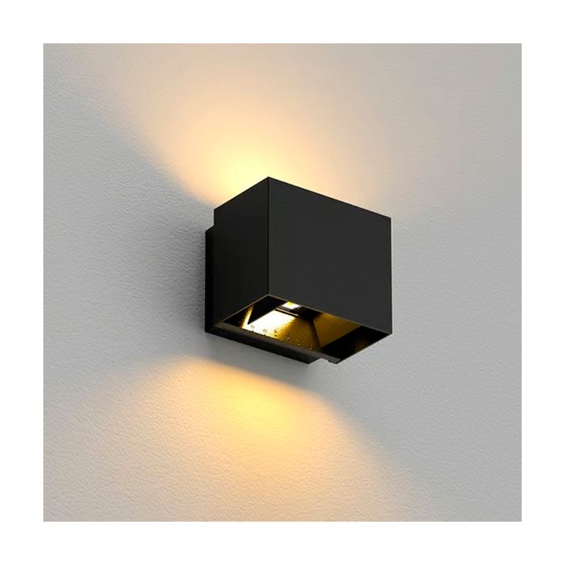 Luminaria de pared exterior LED Pirqa 10 W 3000 K negro Tecnolite, instalada en pared blanca con luz encendida