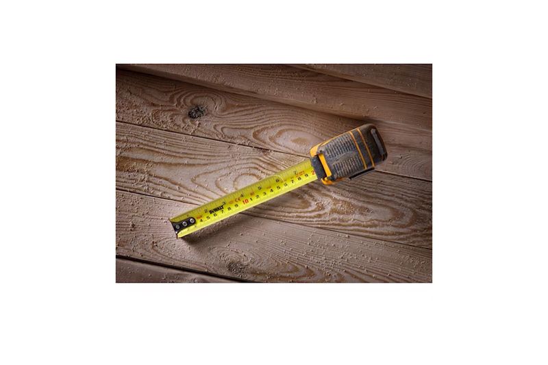 Cinta métrica ToughSeries de 8 m / 26 ft con luz LED DeWALT, extendida sobre una superficie de madera rústica