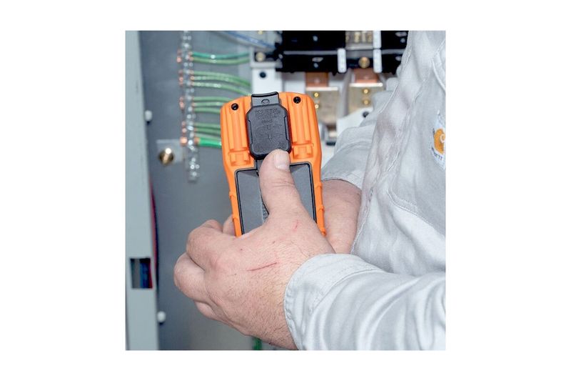 Multímetro digital autorango Klein Tools CAT III, siendo utilizado por un técnico en un panel eléctrico