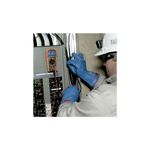 Multímetro digital autorango Klein Tools CAT III, siendo utilizado por un técnico con guantes azules en un tablero eléctrico