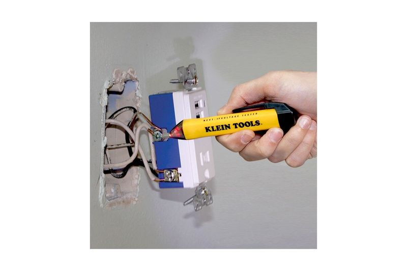 Detector de tensión sin contacto 1000V tipo lápiz Klein Tools, siendo utilizado para probar el voltaje en un tomacorriente