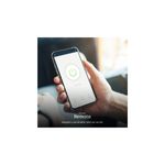 Toma hembra smart con aro de luz RGB Nexxt, mano sosteniendo teléfono móvil con aplicación de control remoto abierta
