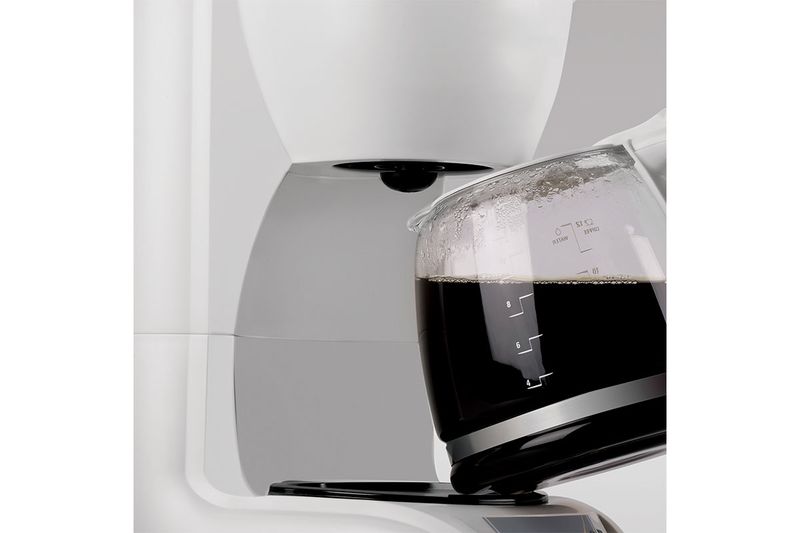 Cafetera blanca de 12 tazas con filtro permanente Black + Decker, primer plano de la jarra de vidrio con café caliente