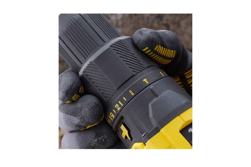 Taladro inalámbrico 1/2 pulgada V20 Stanley, primer plano del anillo de ajuste de torque sostenido por manos con guantes
