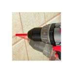 Broca diamantada para cerámica 1 pulgada Milwaukee, instalada en un taladro perforando una pared de cerámica beige
