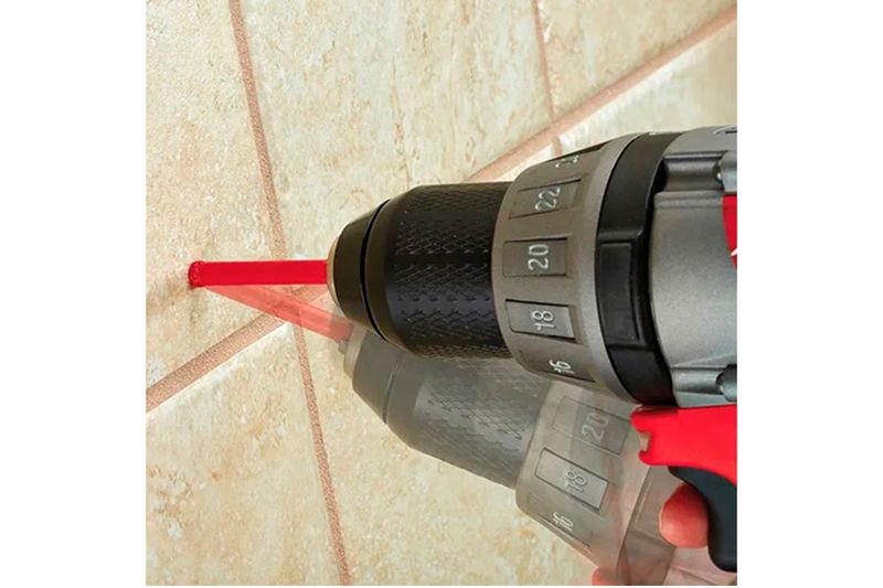 Broca diamantada para cerámica 1 pulgada Milwaukee, instalada en un taladro perforando una pared de cerámica beige