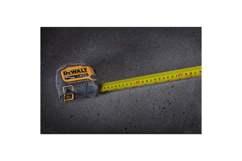 Cinta métrica ToughSeries de 8 m/26 ft con luz LED DeWALT, extendida sobre superficie oscura