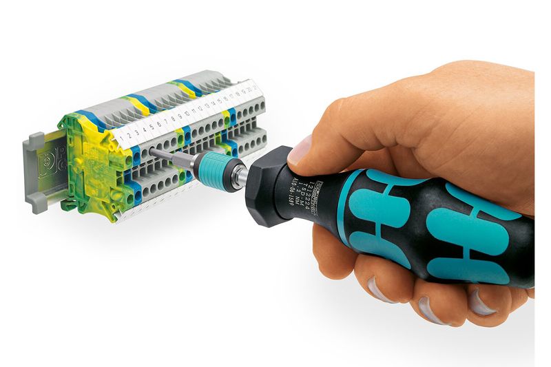 Destornillador dinamométrico de precisión Phoenix Contact, mano utilizándolo para ajustar un terminal eléctrico gris