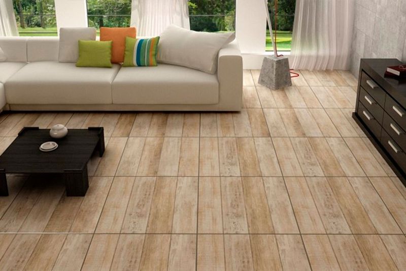 Baldosa 62 x 62 Laminum Mix Plus Madera Satinado Cecafi, instalada en piso de sala con sofá y mesa de centro