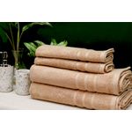 Toalla de baño Nautica de 30 x 60 pulgadas color sand, cuatro toallas dobladas y apiladas junto a accesorios de baño