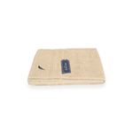 Toalla de baño Nautica de 30 x 60 pulgadas color sand, doblada con etiqueta azul y logo bordado