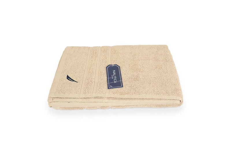 Toalla de baño Nautica de 30 x 60 pulgadas color sand, doblada con etiqueta azul y logo bordado