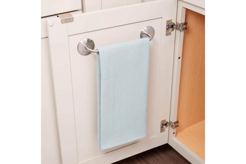 Toallero barra 11 pulgadas cromado Interdesign, instalado en puerta de gabinete blanco con una toalla celeste