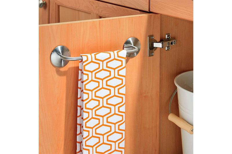 Toallero barra 11 pulgadas cromado Interdesign, instalado en puerta de madera con una toalla blanca y naranja colgada
