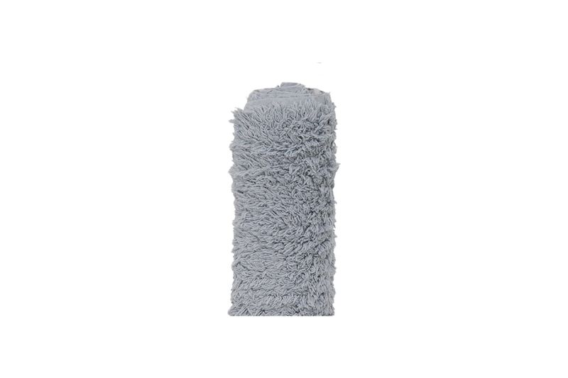 Alfombra de baño surt 60x90 cm Koopman, enrollada en color gris con textura de fibras largas y suaves