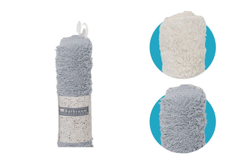 Alfombra de baño surt Koopman de 60x90 cm, enrollada en color gris y opciones en blanco y gris sobre fondos azules